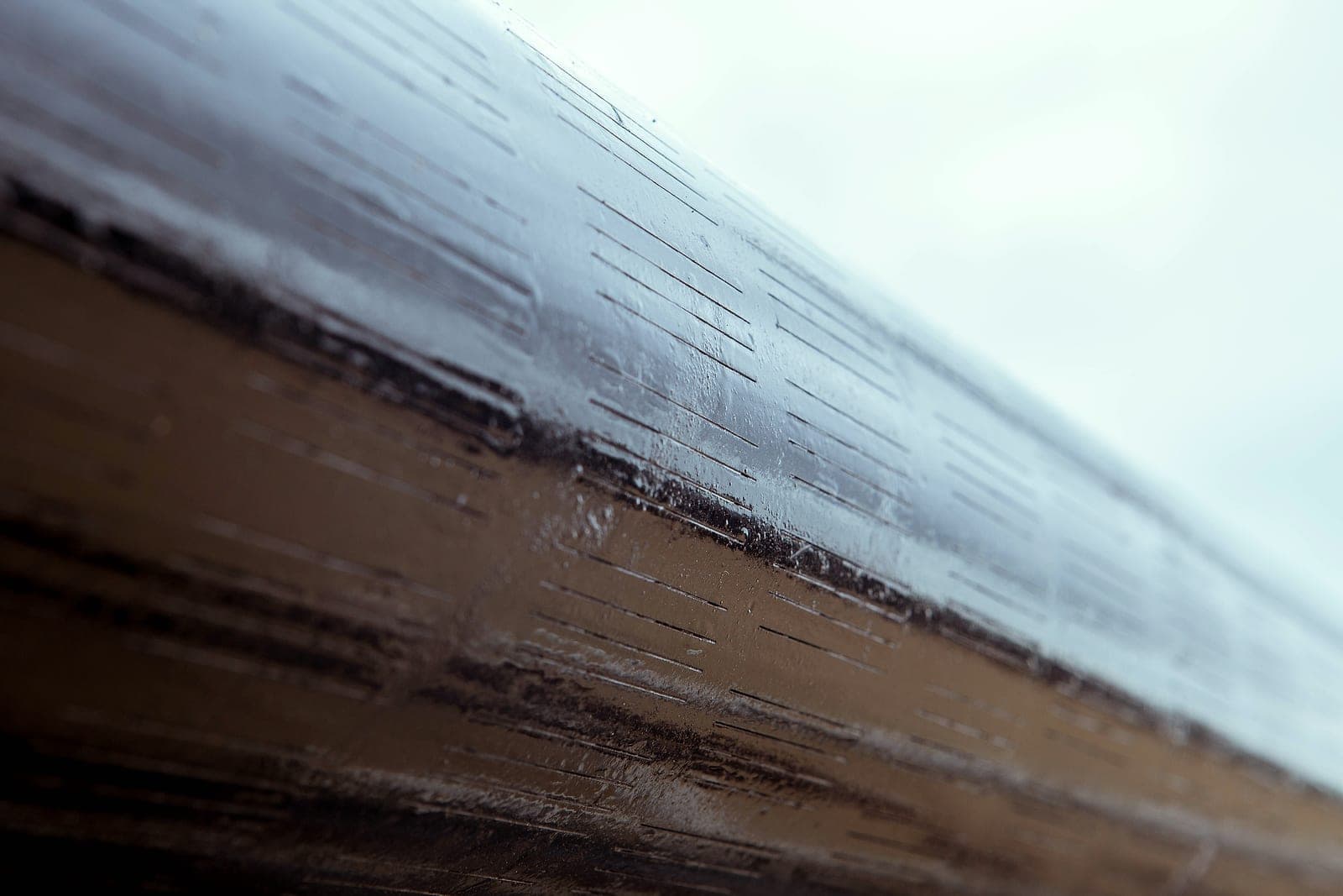 A slotted liner body, close: rows of narrow lengthwise slots.