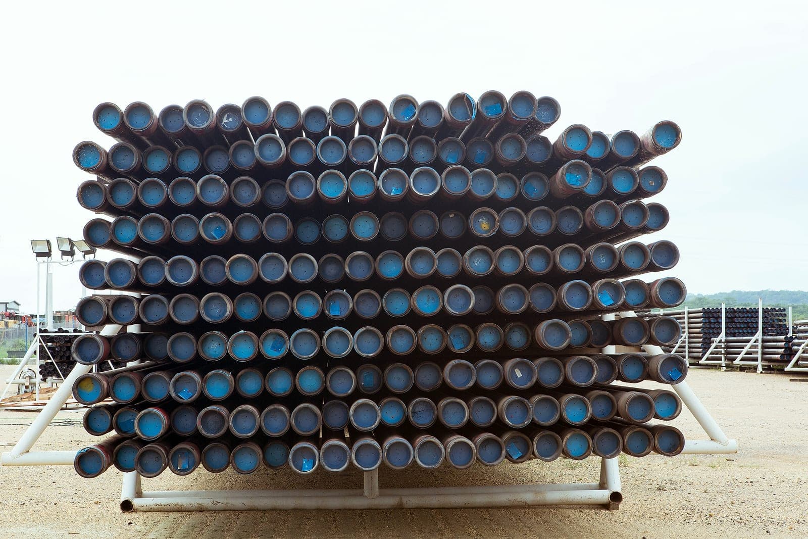 Liner ends with blue thread protectors, stacked on a white rack.