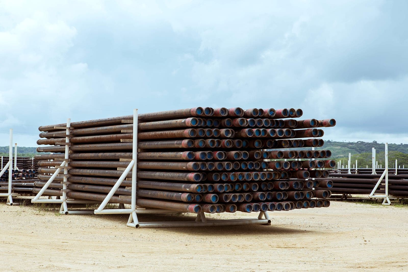 A tall rack of coated tubulars, liner ends to the camera.